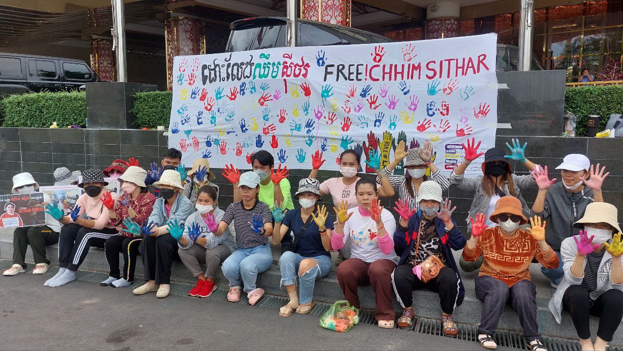 Protesters stand in front of a sign they painted during a protest at Nagaworld 2 Casino and Hotel in Phnom Penh on 20 July 2023. Photo: Danielle Keeton-Olsen
